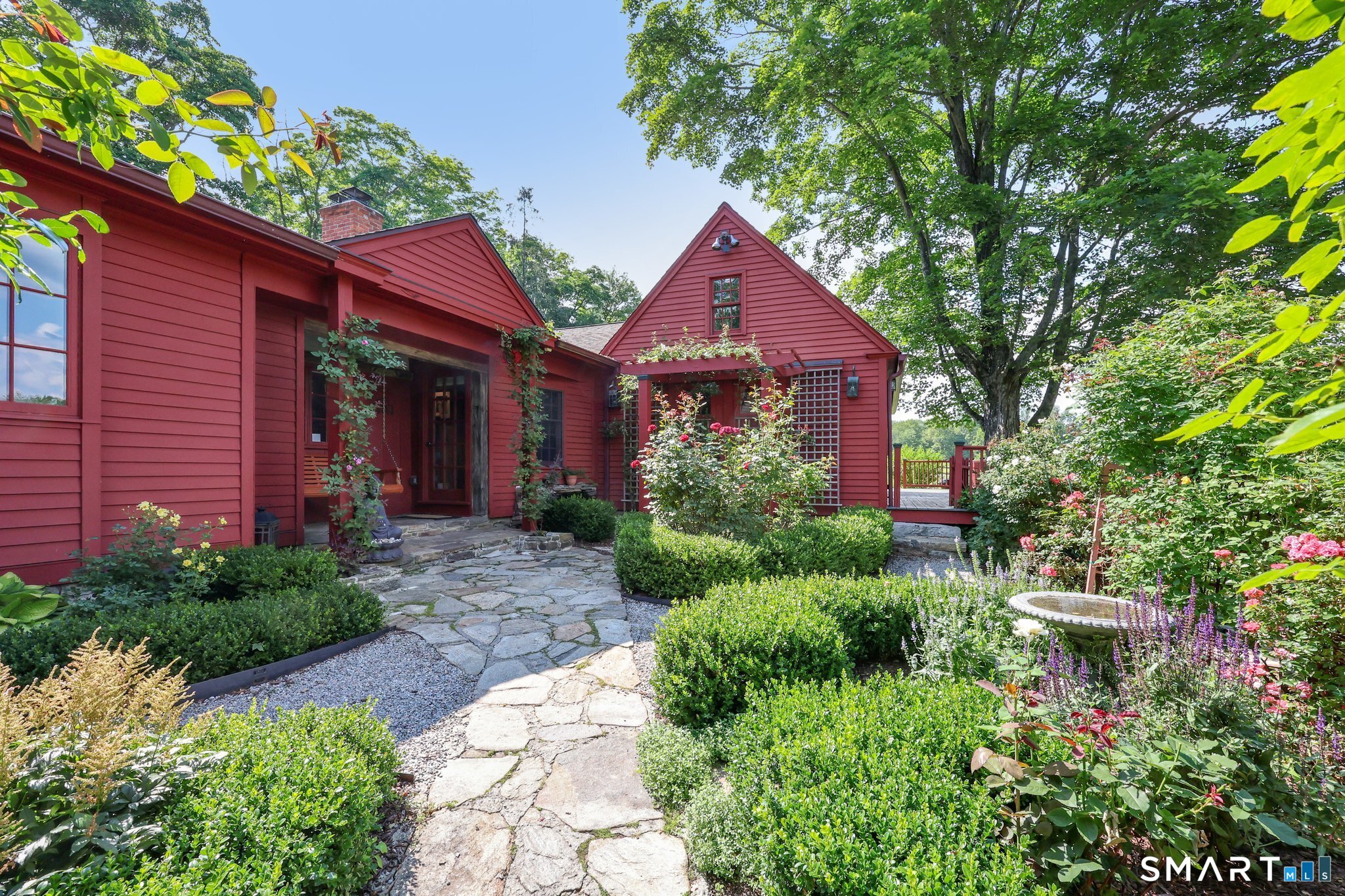12 Jackson Road Killingworth, CT 06419 - Photo 2 of 40 Magical side view of the property featuring a waterfall fountain, covered porch and swing, birdbath and 3 arbors. This is a tranquil and most beautiful setting.