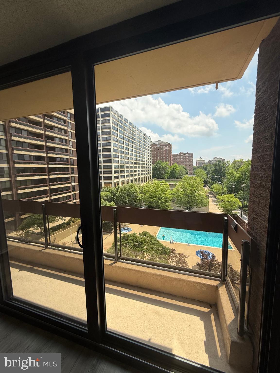 4100 North Charles Street, Unit 507 Baltimore, MD 21218 - Photo 18 of 20 Sunny balcony view overlooking lush greenery.