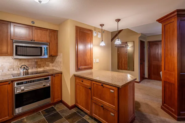 a kitchen with stainless steel appliances granite countertop a stove and a microwave