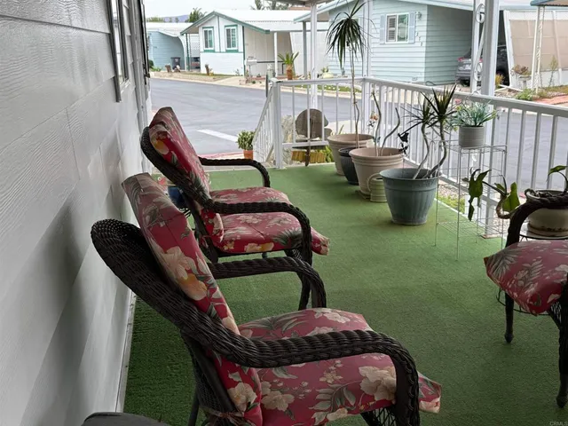 a balcony with chairs and a potted plant