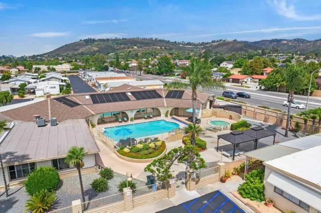an aerial view of residential houses with outdoor space and parking