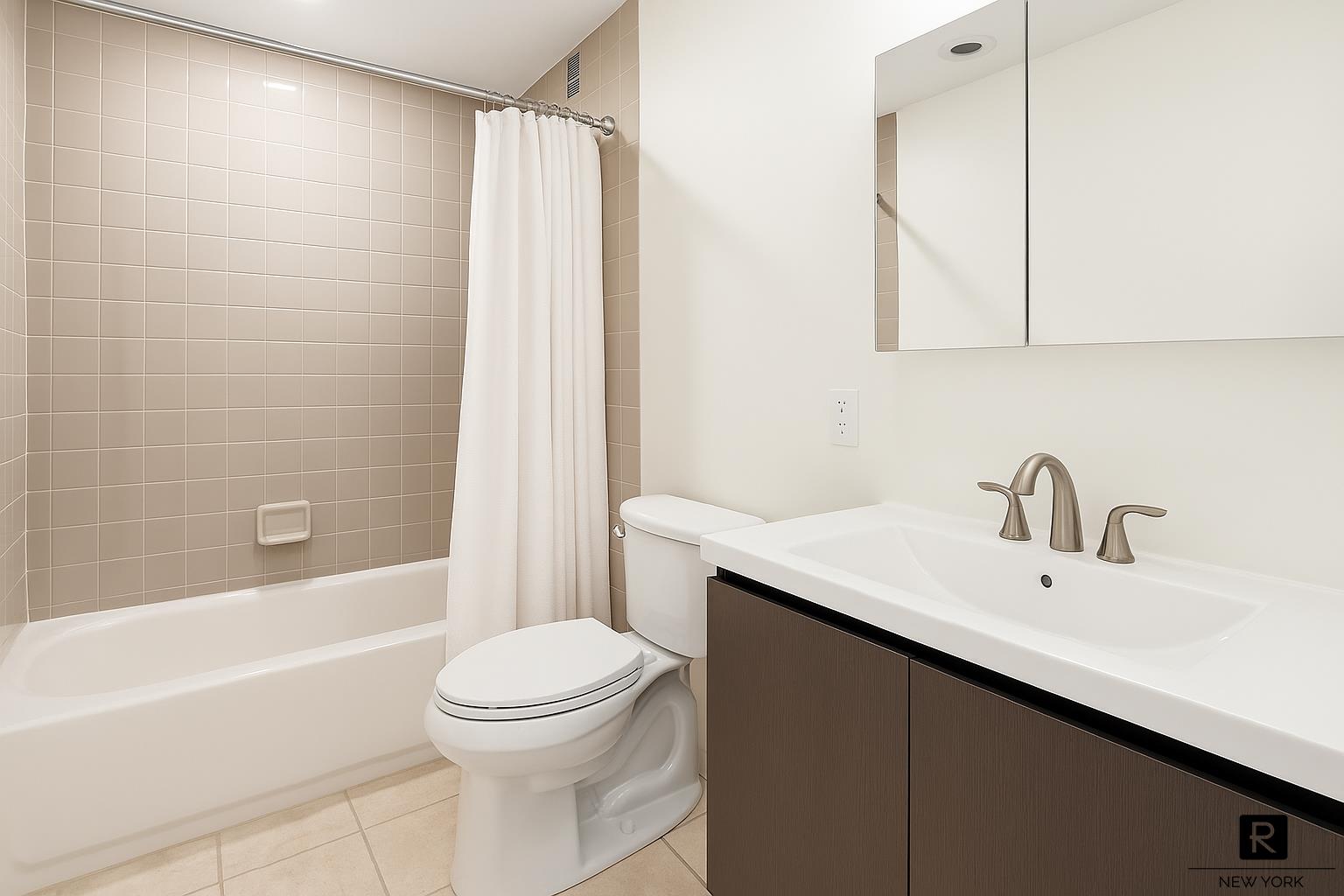 153 East 87th Street, Unit 9D Manhattan, NY 10128 - Photo 6 of 9 a bathroom with a sink a toilet and shower