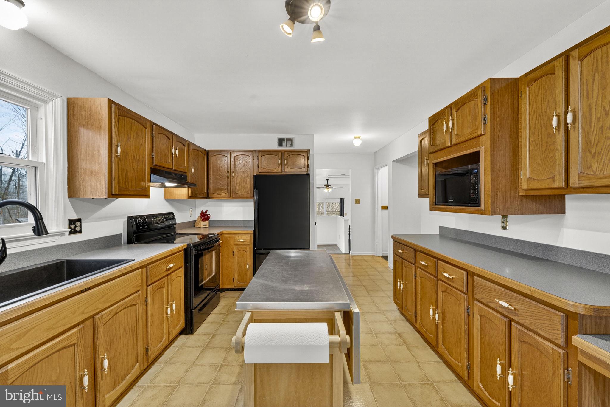 2266 Beaver Dam Road Midland, VA 22728 - Photo 29 of 93 a large kitchen with stainless steel appliances granite countertop a stove a sink dishwasher and a microwave oven with cabinets