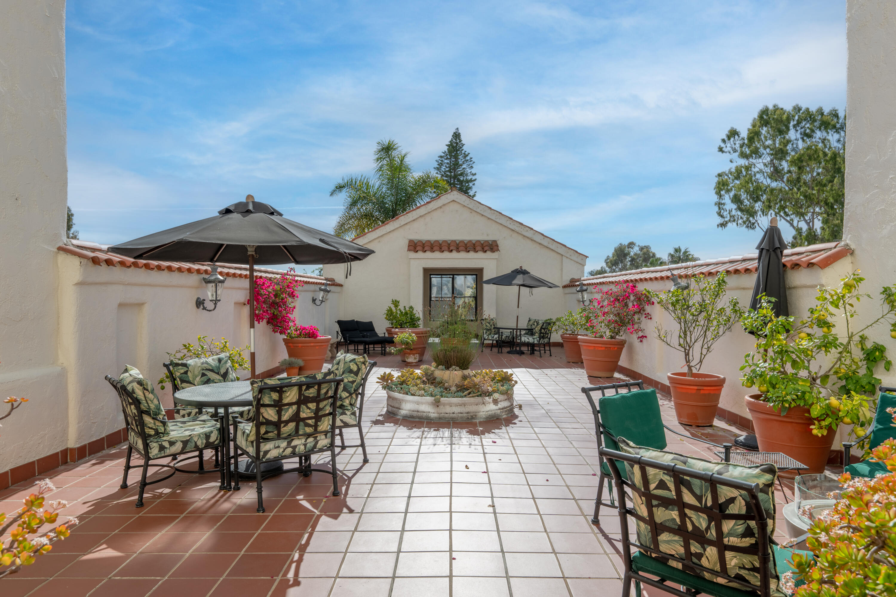 1220 Coast Village Road, Unit 303 Santa Barbara, CA 93108 - Photo 25 of 29 a view of a patio with table and chairs potted plants