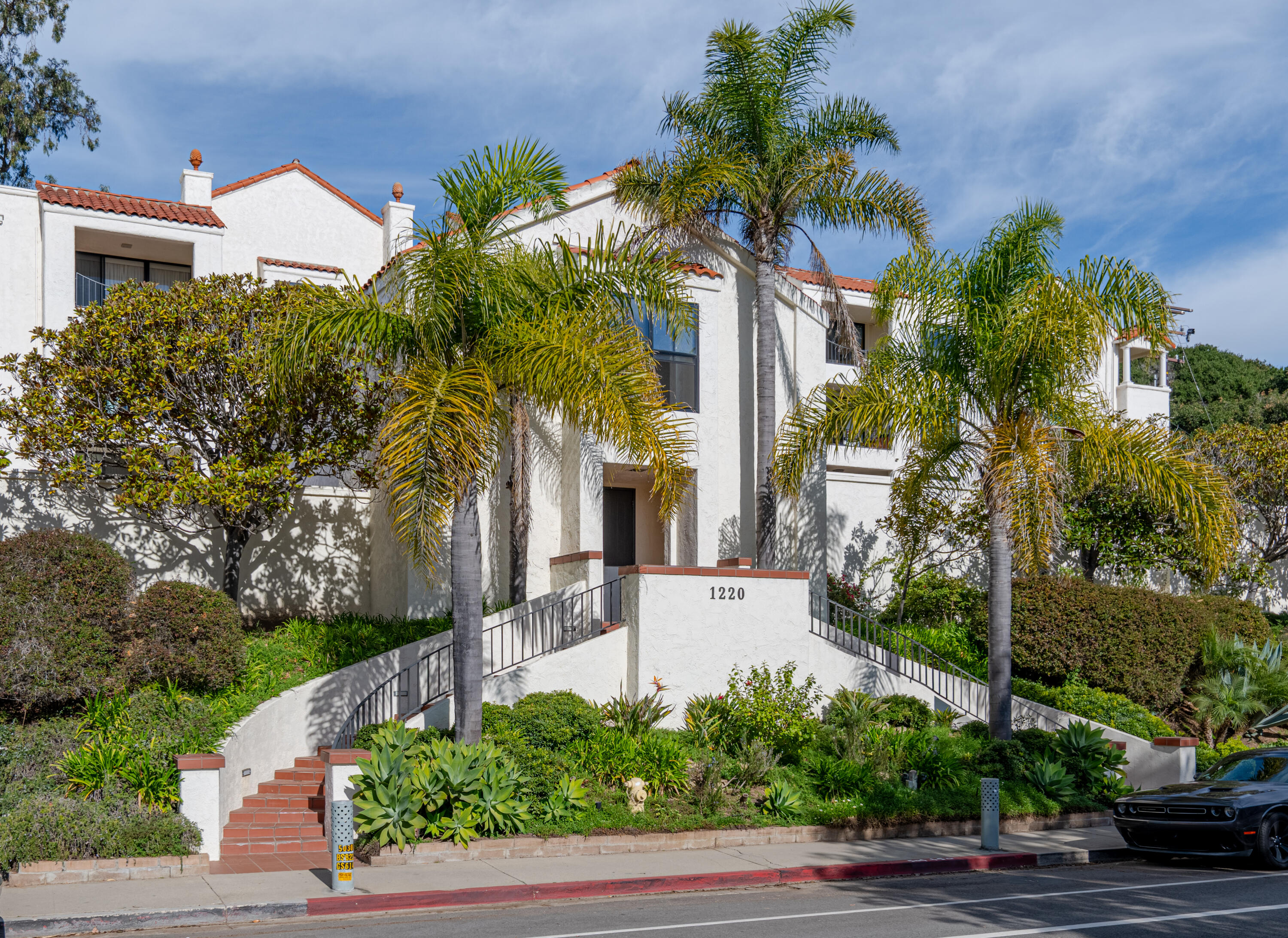1220 Coast Village Road, Unit 303 Santa Barbara, CA 93108 - Photo 4 of 29 a front view of a house with a yard and potted plants
