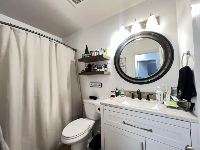 a bathroom with a sink a mirror a toilet and a mirror