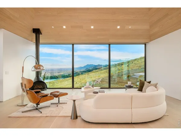 a living room with furniture and floor to ceiling windows