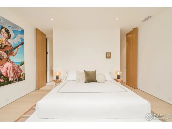 a bedroom with a bed and a painting on the wall