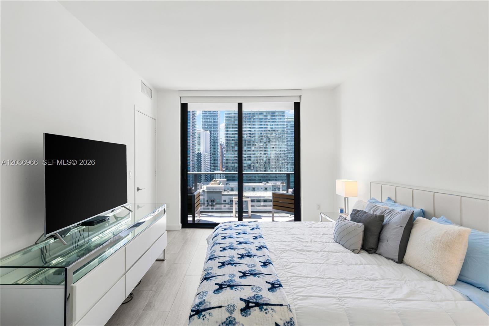 55 Southwest 9th Street, Unit 1904 Miami, FL 33130 - Photo 39 of 66 a bedroom with a large bed and a flat tv screen next to a window