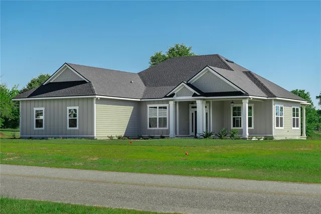 a white house with a small yard and a large window
