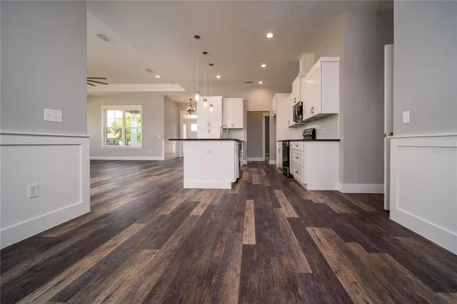 a open kitchen with white cabinets and stainless steel appliances
