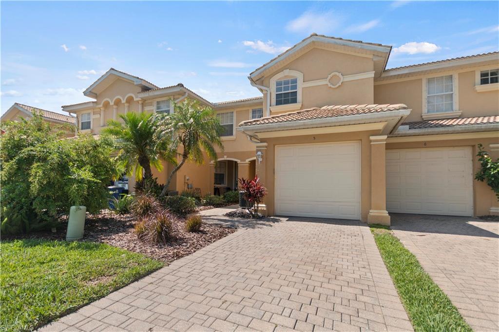 9801 Foxhall Way, Unit 5 Estero, FL 33928 - Photo 1 of 26 a front view of a house with a yard and garage