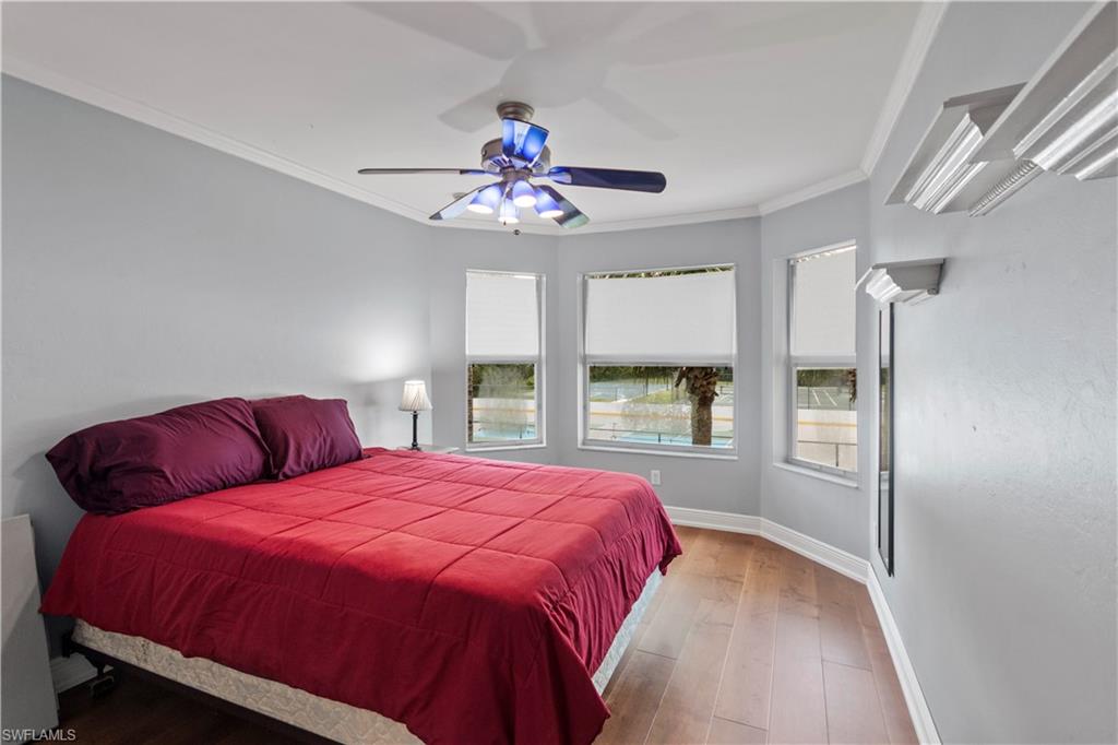 9801 Foxhall Way, Unit 5 Estero, FL 33928 - Photo 14 of 26 a bedroom with a large bed and a chandelier