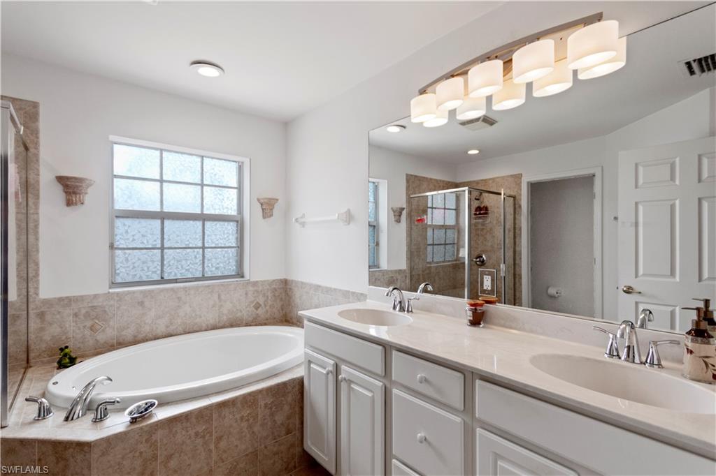 9801 Foxhall Way, Unit 5 Estero, FL 33928 - Photo 17 of 26 a bathroom with a large tub sink and mirror