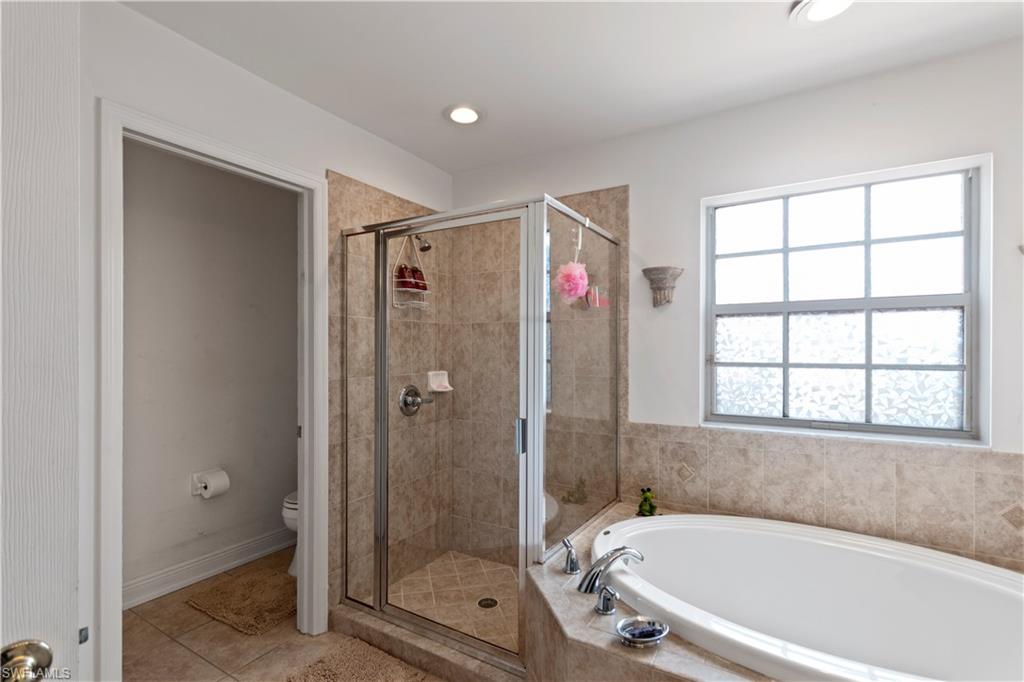 9801 Foxhall Way, Unit 5 Estero, FL 33928 - Photo 18 of 26 a bathroom with a tub and shower