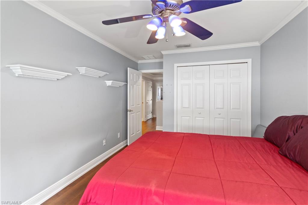 9801 Foxhall Way, Unit 5 Estero, FL 33928 - Photo 19 of 26 a bedroom with a large bed and a chandelier