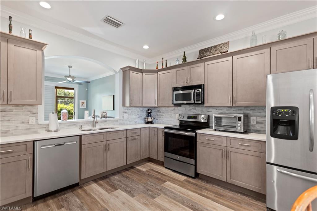 9801 Foxhall Way, Unit 5 Estero, FL 33928 - Photo 2 of 26 a kitchen with a sink stainless steel appliances and white cabinets