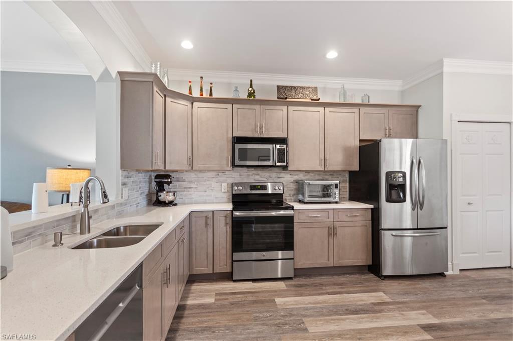 9801 Foxhall Way, Unit 5 Estero, FL 33928 - Photo 3 of 26 a kitchen with stainless steel appliances a refrigerator sink and microwave