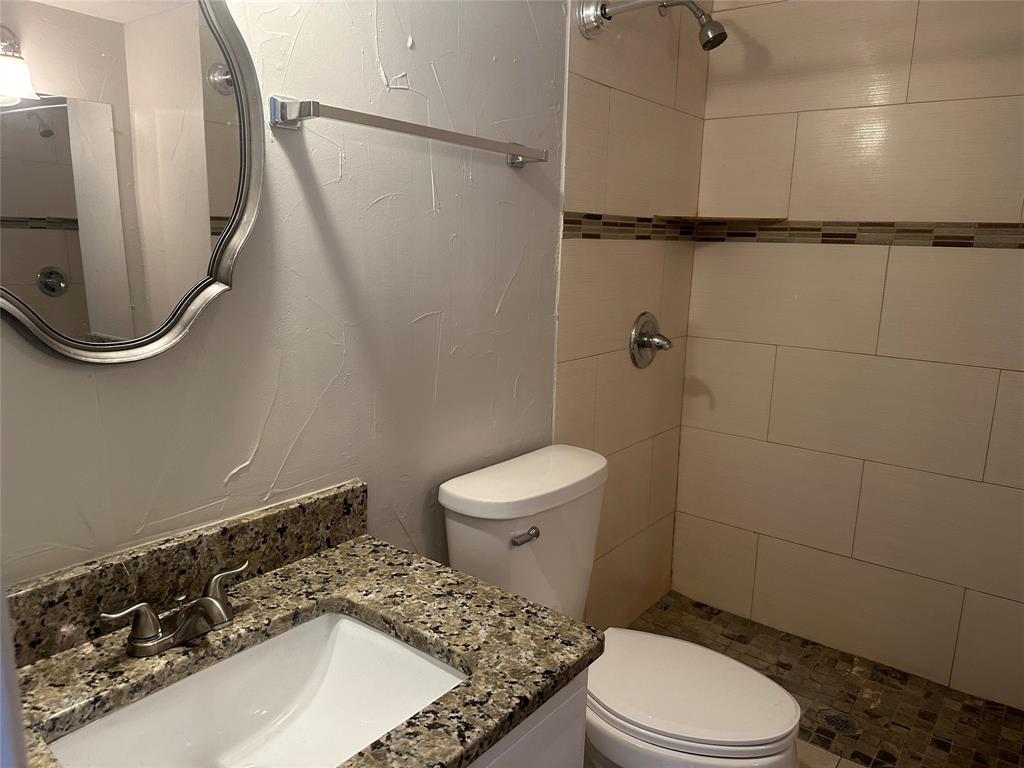 3121 Park Lane, Unit 1147 Dallas, TX 75220 - Photo 11 of 22 a bathroom with a sink a toilet and a mirror