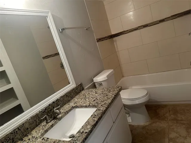 a white toilet sitting next to a bath tub and a shower