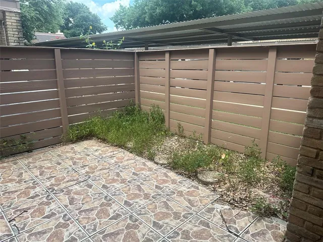 a view of a backyard with chair and wooden fence