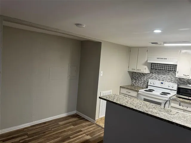 a kitchen with granite countertop a sink and a stove top oven