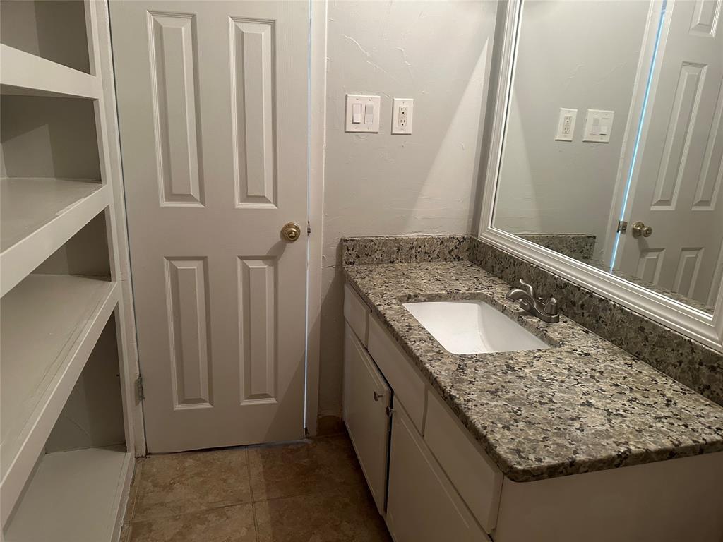3121 Park Lane, Unit 1147 Dallas, TX 75220 - Photo 10 of 22 a bathroom with a granite countertop sink and a mirror
