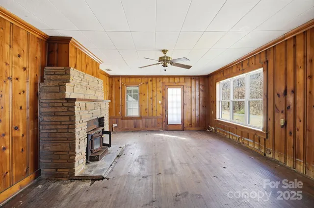 a view of an empty room with a fireplace and a window
