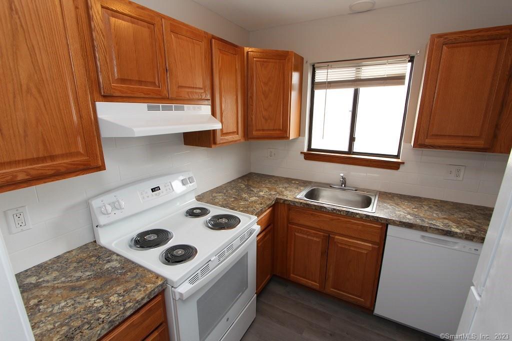 1400 Meriden Road, Unit 52 Waterbury, CT 06705 - Photo 5 of 21 a kitchen with granite countertop a sink a stove and cabinets