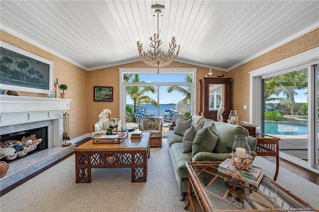 4110 Northeast Joes Point Road Stuart, FL 34996 - Photo 33 of 67 a living room with furniture a fireplace and a floor to ceiling window