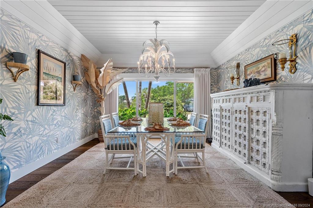 4110 Northeast Joes Point Road Stuart, FL 34996 - Photo 35 of 67 a view of a dining room with furniture a chandelier and large window