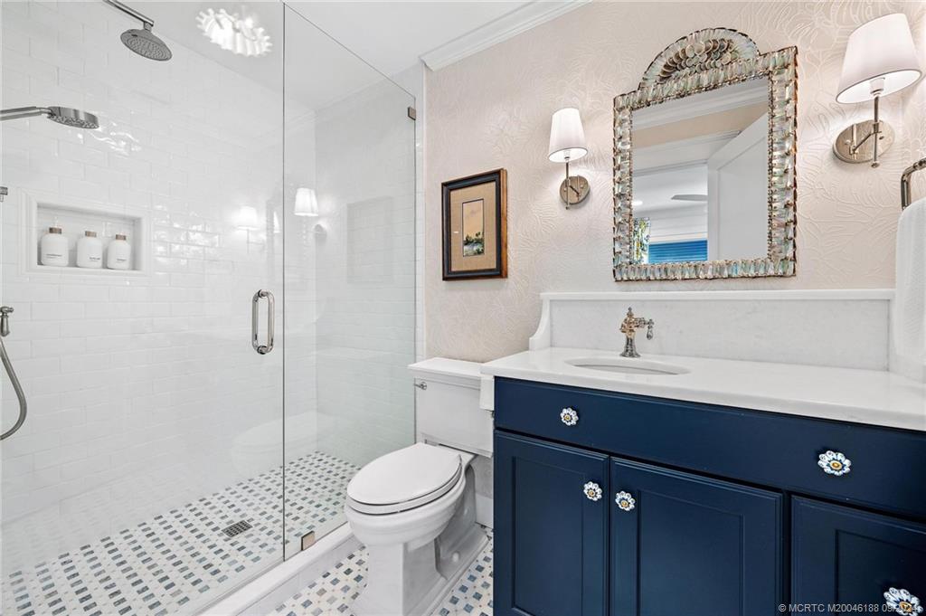 4110 Northeast Joes Point Road Stuart, FL 34996 - Photo 49 of 67 a bathroom with a toilet a sink a glass door a shower a mirror and vanity