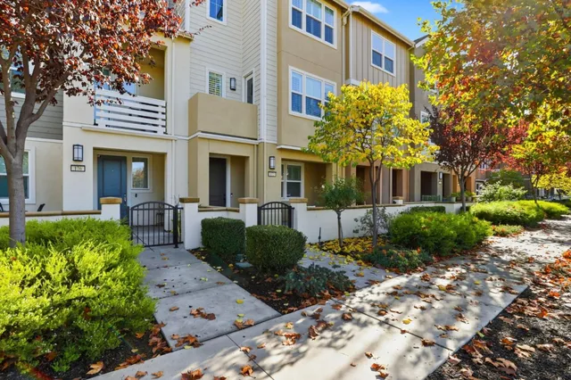 a kitchen with stainless steel appliances granite countertop a sink dishwasher a stove top oven a refrigerator with island and chairs