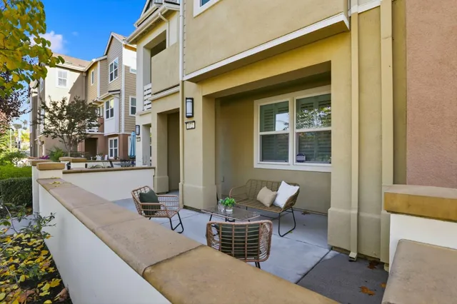 a kitchen with stainless steel appliances kitchen island granite countertop a dining table chairs and refrigerator