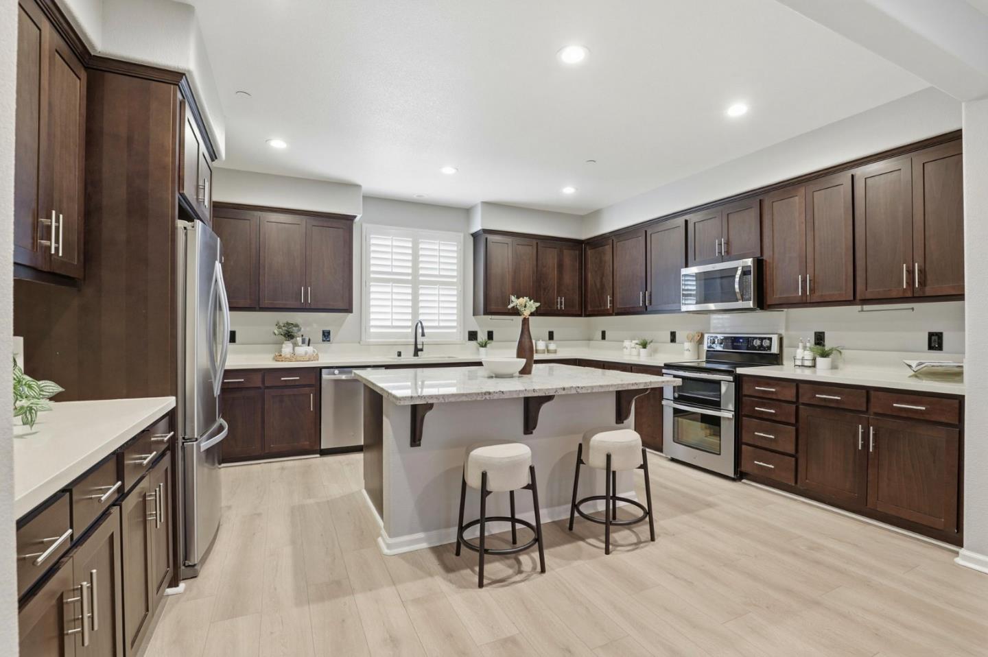 172 East Main Avenue Morgan Hill, CA 95037 - Photo 8 of 36 a kitchen with stainless steel appliances granite countertop a sink dishwasher a stove top oven a refrigerator with island and chairs