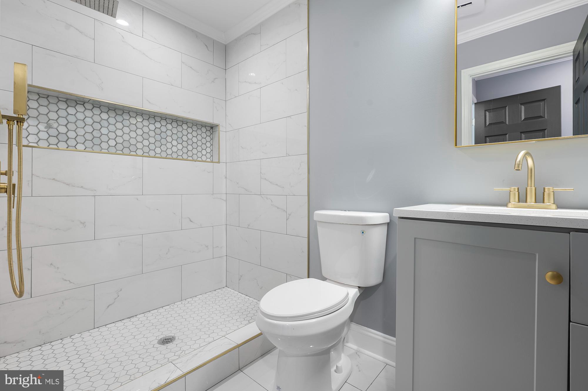 1513 North Wolfe Street Baltimore, MD 21213 - Photo 15 of 33 a bathroom with a toilet a sink a mirror and shower