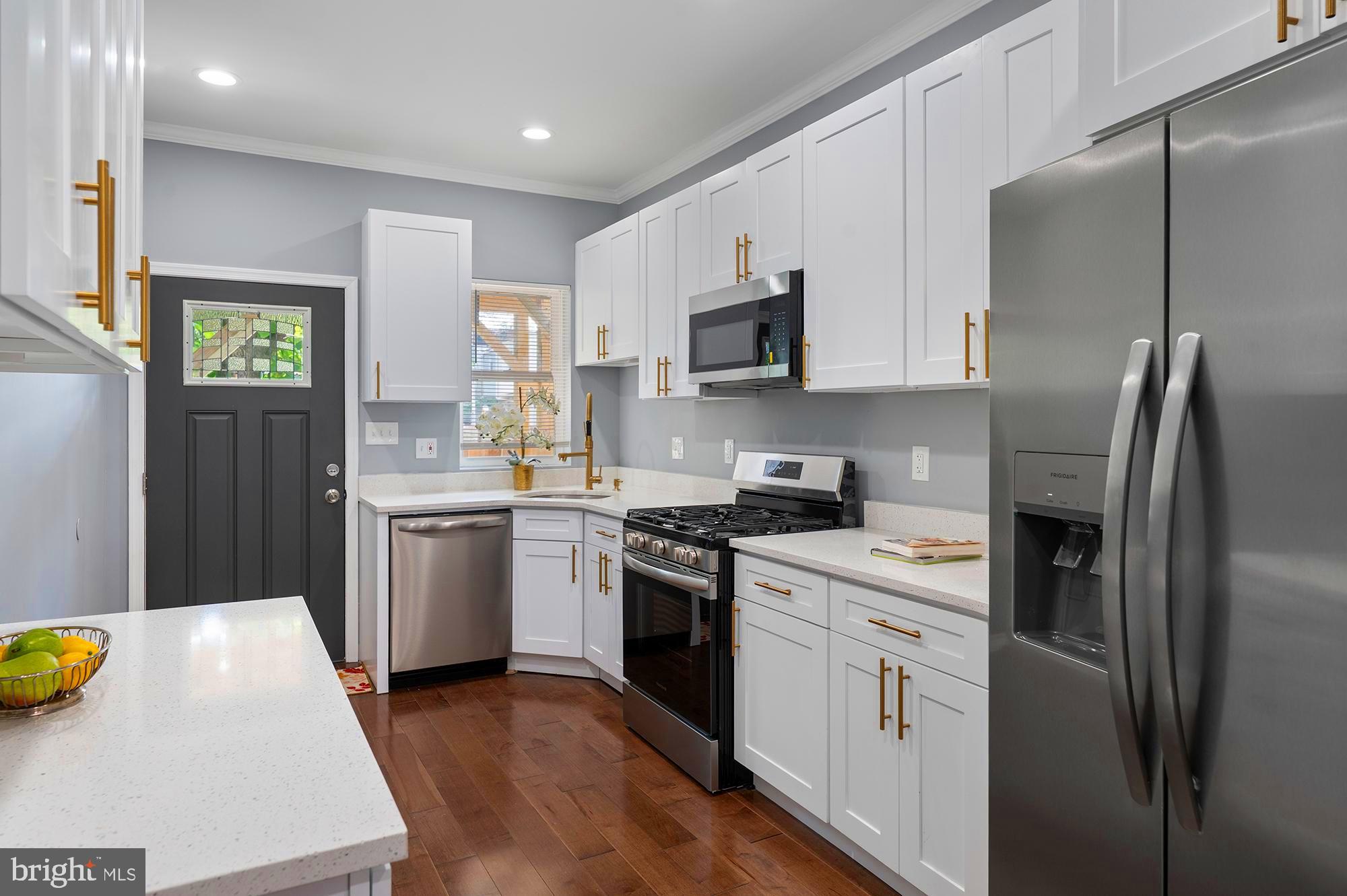 1513 North Wolfe Street Baltimore, MD 21213 - Photo 7 of 33 a kitchen with stainless steel appliances a sink a stove a refrigerator cabinets and a window