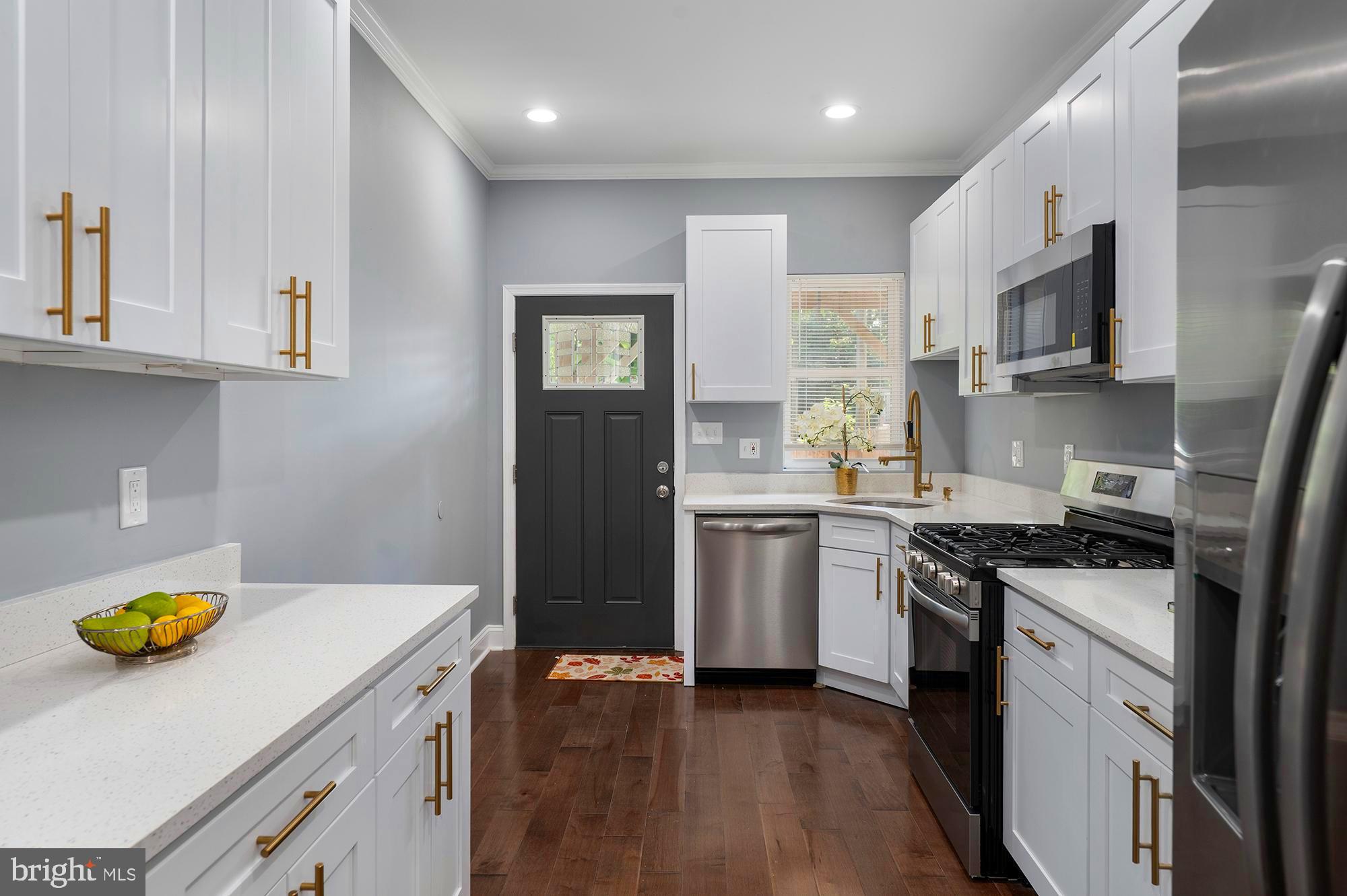 1513 North Wolfe Street Baltimore, MD 21213 - Photo 8 of 33 a kitchen with a sink a stove and refrigerator
