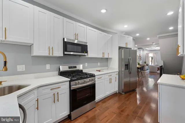 a kitchen with stainless steel appliances granite countertop a refrigerator stove microwave and sink