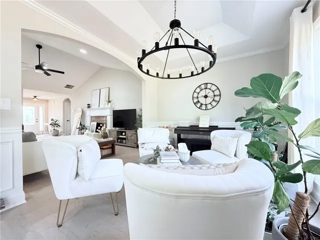 a living room with furniture a chandelier and a flat screen tv