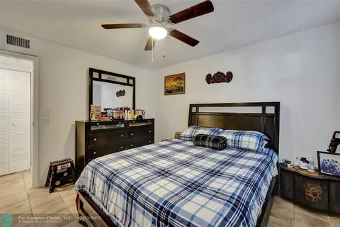 a bedroom with a bed and a lamp on the dresser