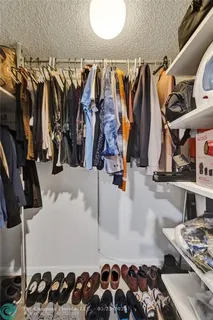 a view of walk in closet with clothes and shoes