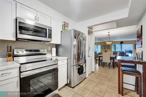 a kitchen with granite countertop a refrigerator stove and microwave