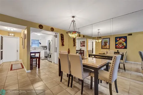 a dining area with chandelier and table
