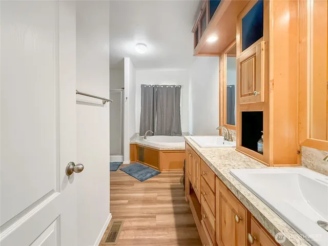 a bathroom with a tub sink and mirror