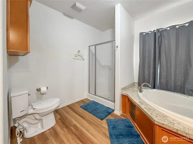 a bathroom with a granite countertop tub sink and mirror