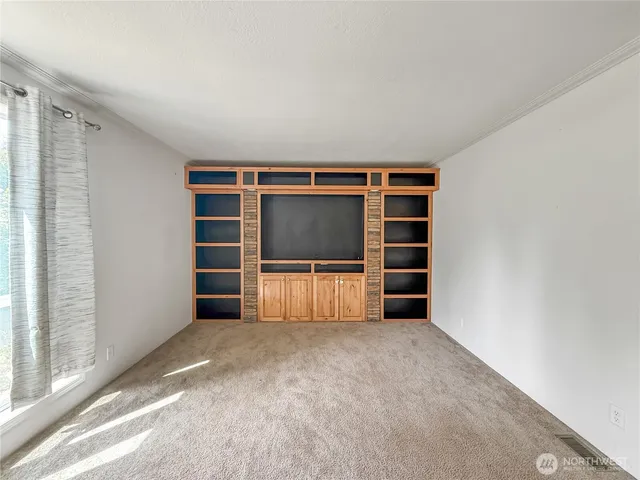 a view of an empty room with a fireplace and a window