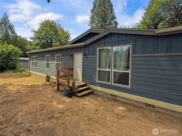 a view of backyard with wooden fence and a large tree