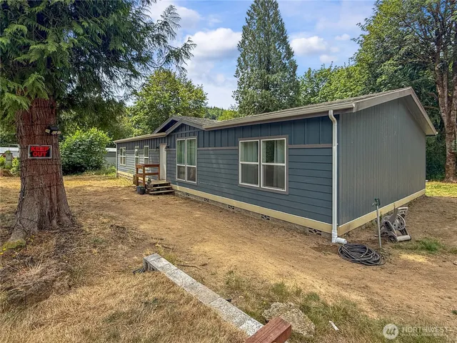 a view of a house with backyard and trees