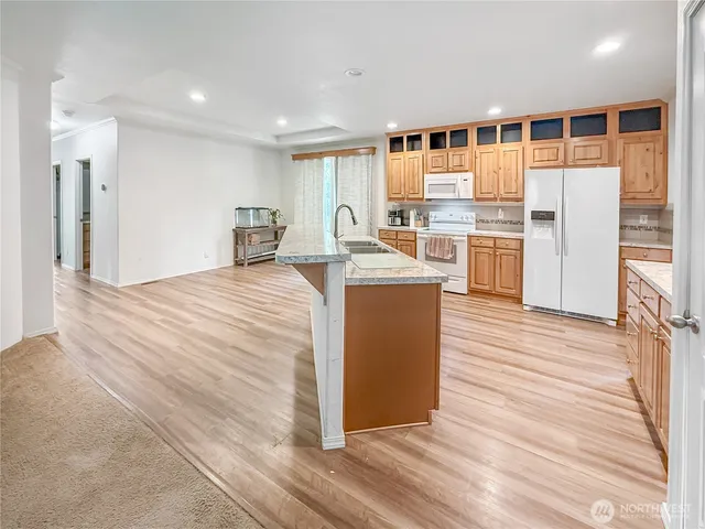 a kitchen with stainless steel appliances granite countertop a refrigerator a stove and a wooden floors